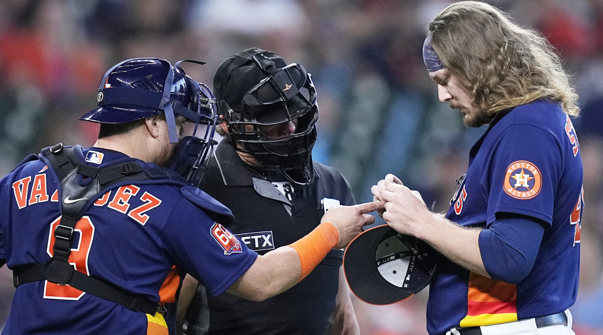 Astros pitcher Ryne Stanek tries to adjust his PitchCom device.